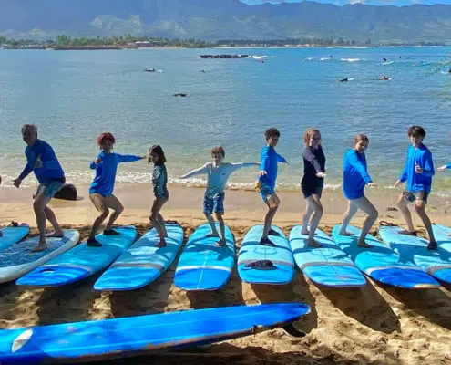 North Shore Oahu surf school lessons, Hawaii. Students practice how to stand on a surf board.