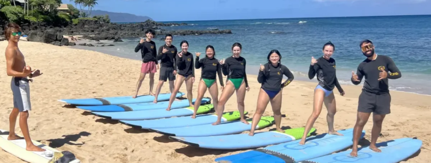 North Shore Oahu Surf School first lesson on land teaches students how to stand on a surfboard.