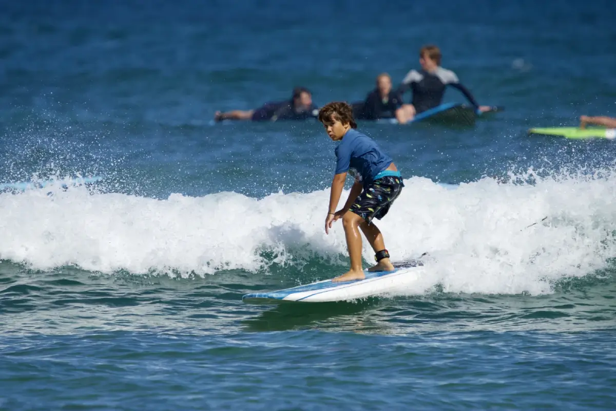 Student's first time surfing in Hawaii. Surf camp and classes help youth get started surfing in Oahu.