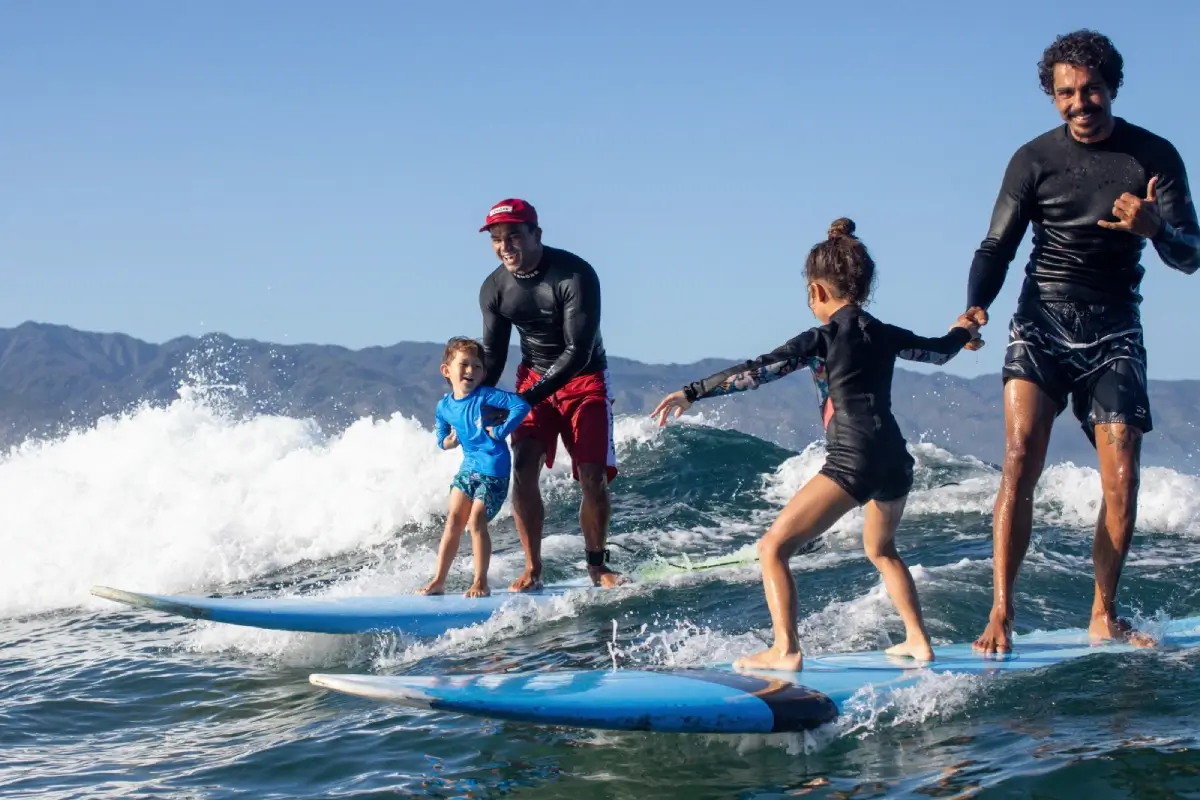 Surf instructors teach kids how to surf. Oahu classes for beginners with Kala Grace, pro-surf instructor.